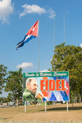 SANTA CLARA, CUBA-JANUARY 6, 2017: Poster with image of Fidel Castro and Cuban flag in the Plaza de la Revolucion in the city of Santa Clara, Cuba. Next is the Mausoleum of homage to Ernesto Che Guevara.