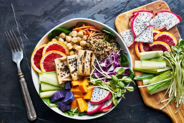 healthy buddha bowl in flat lay composition with colorful ingredients, shot from birds eye view