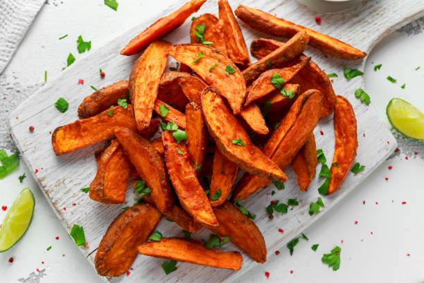 sane spicchi di patate dolci all'arancia al forno fatte in casa con salsa di immersione alla crema fresca, erbe aromatiche, sale e pepe - scarpe con la zeppa foto e immagini stock