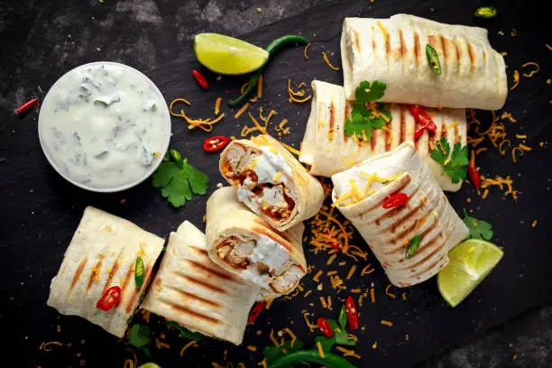 Photo of Healthy grilled chicken and parsley wraps, loaded with cheese, served with greek yogurt deep, chillies and lime slices