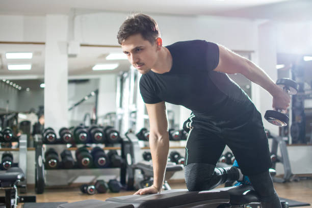 istock Young fit man working out with weights in gym. 915387932