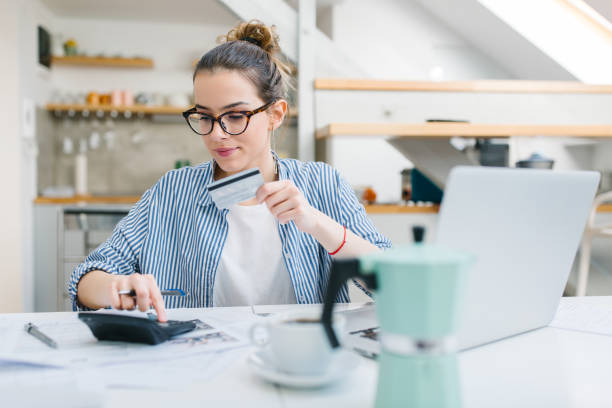 Online shopping Young woman paying bills/ shopping online with credit card credit card women internet currency stock pictures, royalty-free photos & images