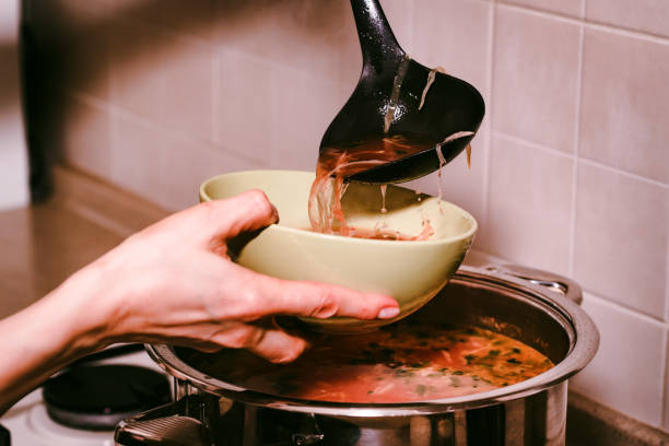 istock Hand pours borscht or red vegetable soup in bowl 915391612