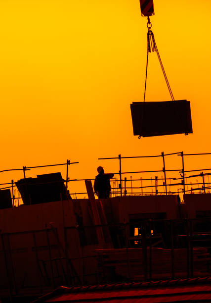 building workers working on a building under a sunset building workers working on a building under a beautiful sunset. Chinese shadow effect. lazy construction laborer stock pictures, royalty-free photos & images