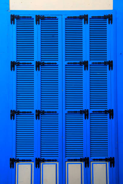 Vintage blue close window with shutters in old stone house, bright blue window shutters pattern