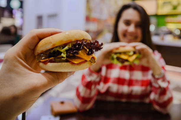 istock couple eat cheeseburgers in cafe 915399070