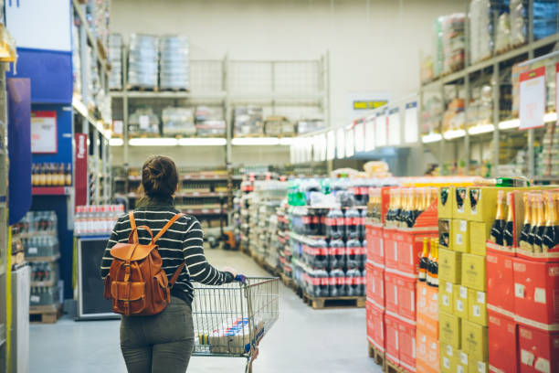 istock woman walk by store with cart 915399826