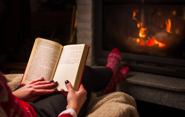 istock Woman reading by the fireplace 915402814