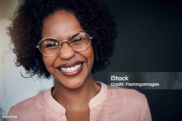 Laughing Young African Businesswoman Standing Alone In A Modern Office Stock Photo - Download Image Now