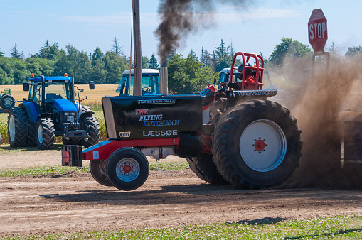 Mon Denmark - July 6. 2014: specially build Tractor pulling competition machine showing how it is done with a wheelie and black smoke