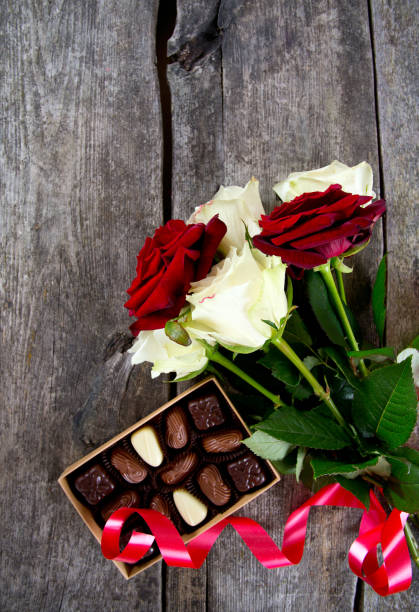 istock roses and chocolate on wooden surface 915442026
