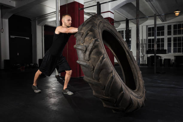 istock Young Man Pushing Tire 915447382