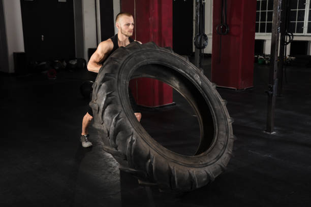 istock Young Man Pushing Tire 915447390