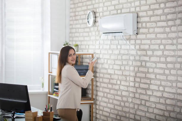 istock Businesswoman Using Remote Control Of Air Conditioner 915448338