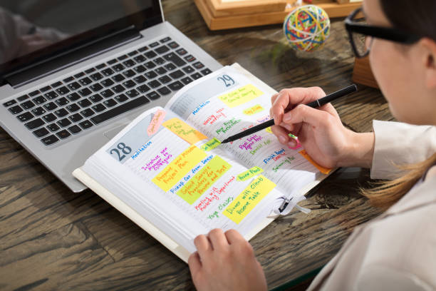 istock Businessperson Writing Schedule In Diary 915451118