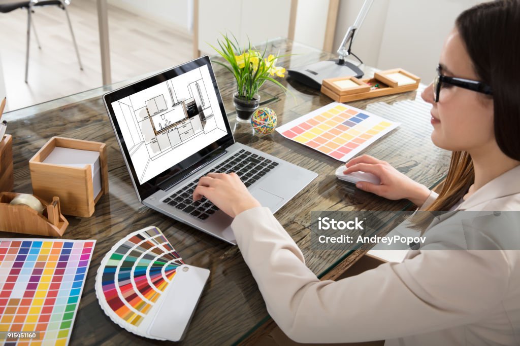 Woman Selecting Color For The Kitchen Room An Female Architect Working On Color Selection For The Kitchen Drawing On Laptop Screen Design Professional Stock Photo