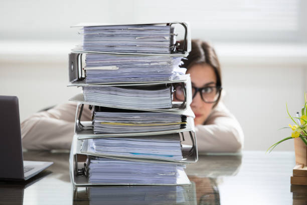 businesswoman hiding behind the folders stack - stack paperwork paper document imagens e fotografias de stock