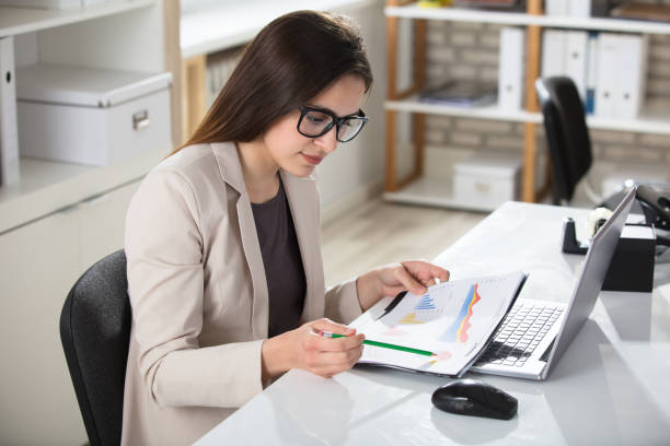 istock Businesswoman Analyzing Graph On Desk 915451400