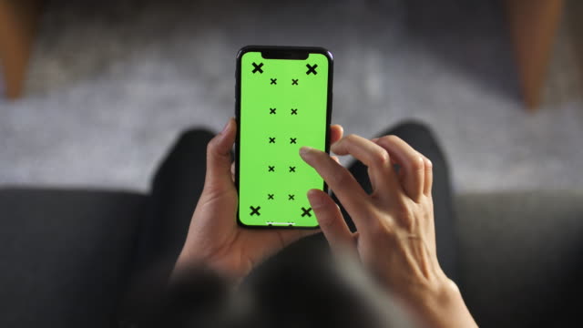Woman Using and Looking Smart phone Green screen at Home