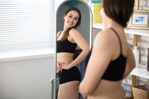 mujer delgada en el espejo - dieting mirror healthy lifestyle women fotografías e imágenes de stock