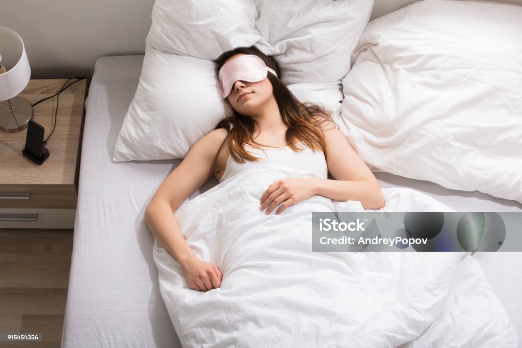 Woman Sleeping On Bed Elevated View Of A Woman With Pink Mask Sleeping On Bed Adult Stock Photo