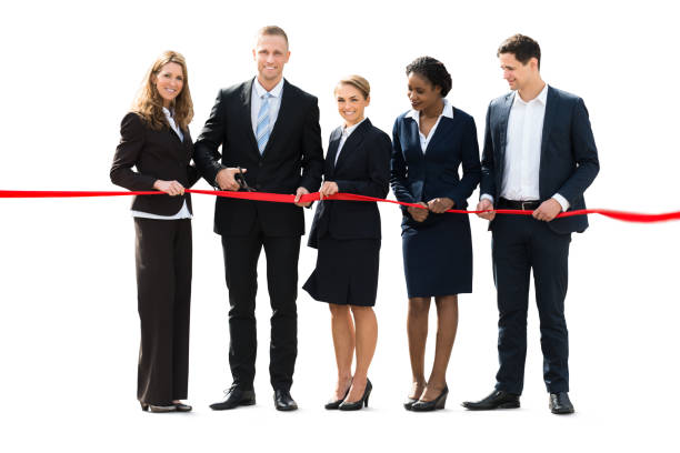 istock Businesspeople Cutting Red Ribbon With Scissors 915454718