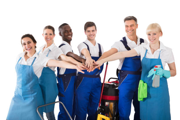istock Group Of Happy Janitors Stacking Hands 915454778