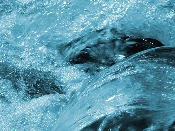A set of rocks in a river with water flowing over them 