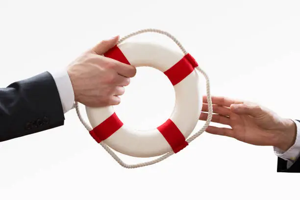 Two Businesspeople Holding Lifebelt On White Background