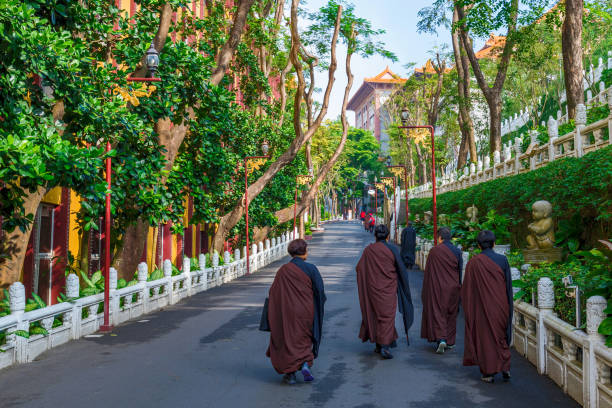 Monks walking a treelined path in the Fo Guang Shan monastery on November 24, 2016 in Kaohsiung