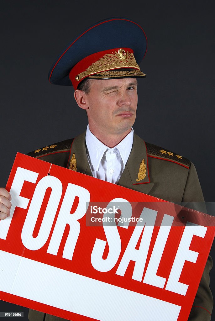 General for Sale Military officer winks as he holds a "for sale" sign, indicating either he or the military is on the take Adult Stock Photo