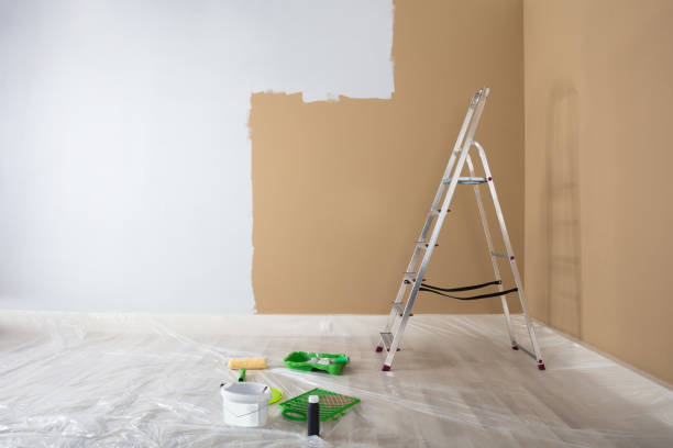 istock Half Painted White Wall With Ladder And Painting Equipments 915461466