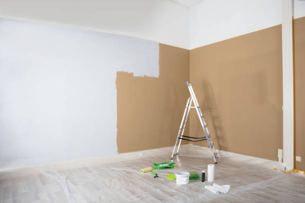 istock Half Painted White Wall With Ladder And Painting Equipments 915461472