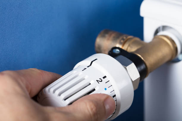 istock Hand Adjusting Temperature On Thermostat 915461738
