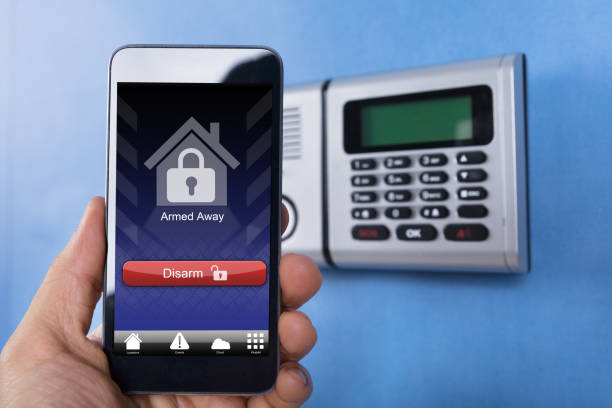 istock Hand Holding Smartphone For Disarming The System 915461782