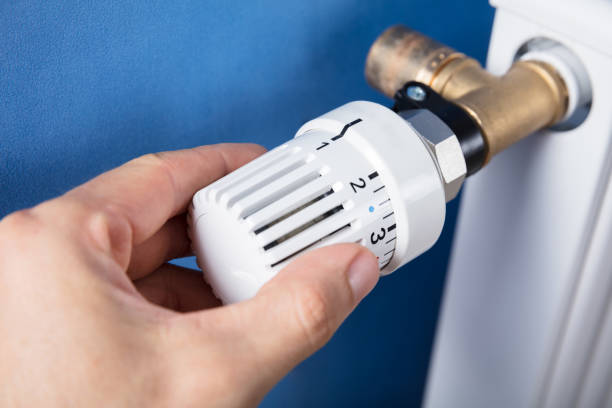 istock Hand Adjusting Temperature On Thermostat 915461906
