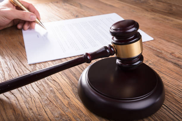 istock Gavel With Person's Hand Signing Legal Document 915463096