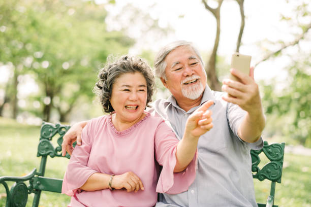istock Asian couple laughing while looking at smartphone 915463386