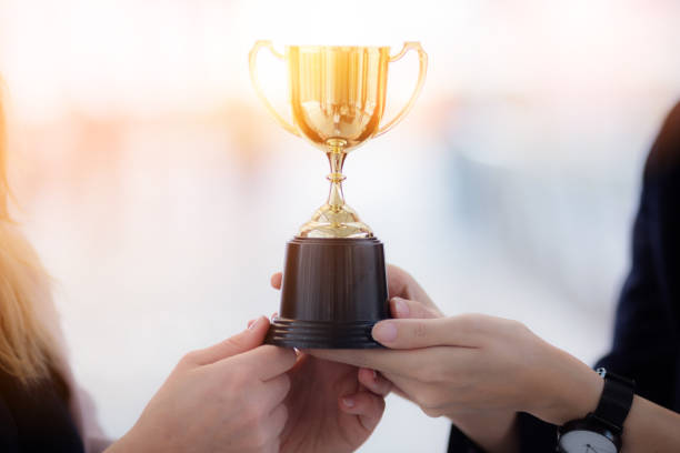 istock business teamwork successful concept with hand hold trophy WITH BLUR BACKGROUND 915483124