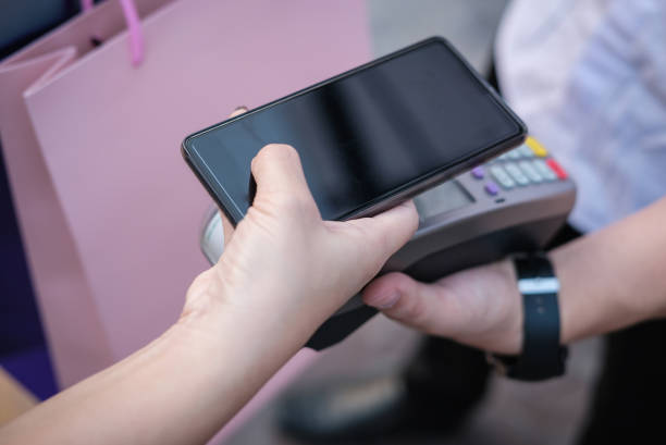 istock woman use smartphone to make mobile payment with electronic reader. customer paying with near field communication, NFC technology. people use app for online shopping. 915483480