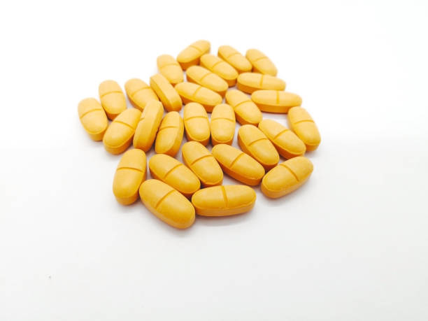Medication and healthcare concept. Many orangeg tablets of Ibuprofen 400 mg. combined with Paracetamol 500 mg. isolated on white background, used to treat muscle inflammation and reduced pain. Focus on foreground and copy space. concepto de medicamentos y atención médica. muchos orangeg comprimidos de ibuprofeno 400 mg. combinado con paracetamol 500 mg. aislados en fondo blanco, utilizado para tratar la inflamación del músculo y dolor reducido. se centran en primer plano y copia espacio.