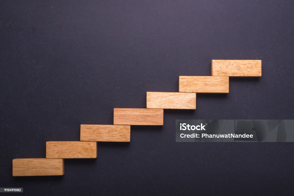 Wooden block set up for staircase on black stone board. Business concept for growth success process. Top view wooden block set up for staircase on black stone board. Business concept for growth success process. Toy Block Stock Photo