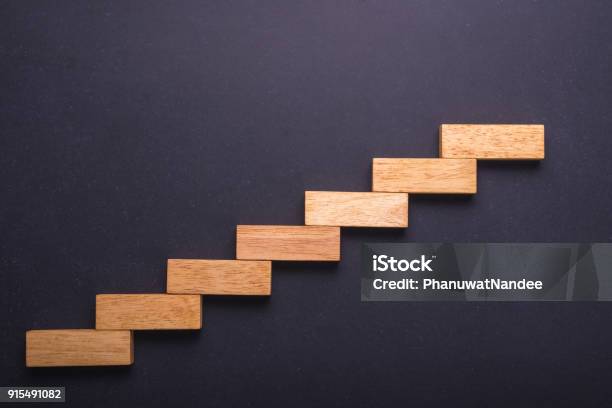 Wooden Block Set Up For Staircase On Black Stone Board Business Concept For Growth Success Process Stock Photo - Download Image Now