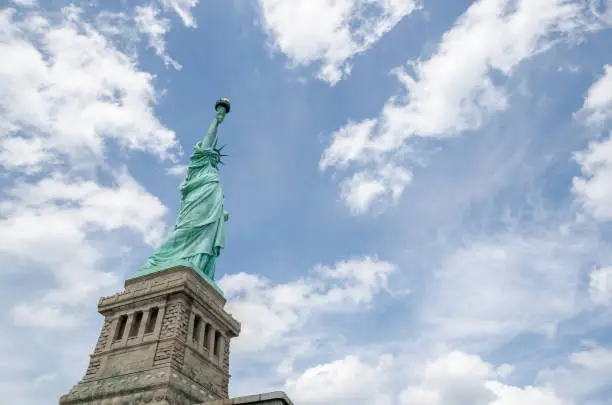 Photo of Statue of liberty, up close with partly cloudy sky