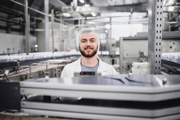 istock Young Handsome Smiling Scientist With Clipboard Posing in Factory 915499490