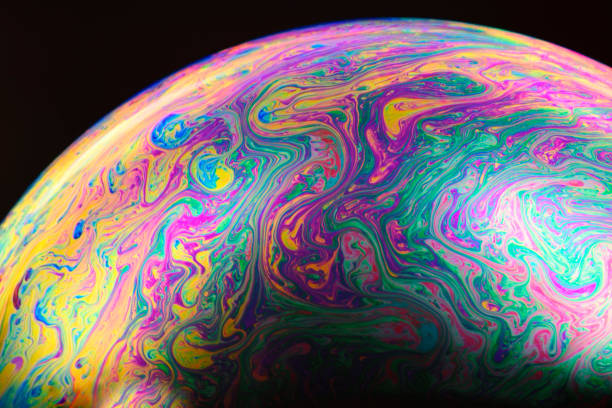 istock Close-up of rainbow colored soap bubble on black background 915499532