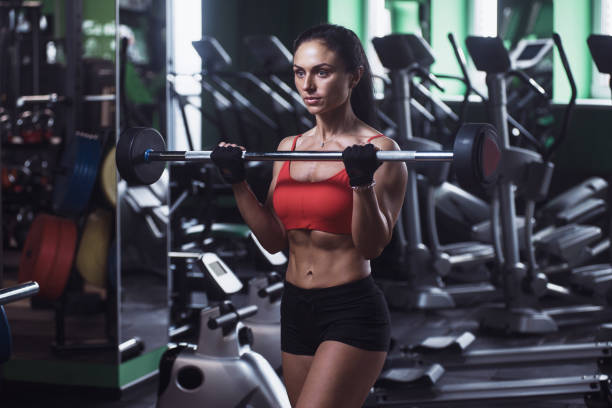 istock athletic young girl training with weight in the gym 915518254
