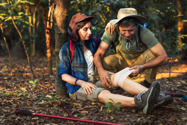 istock Man putting bandage on his partner knee in the jungle 915524832