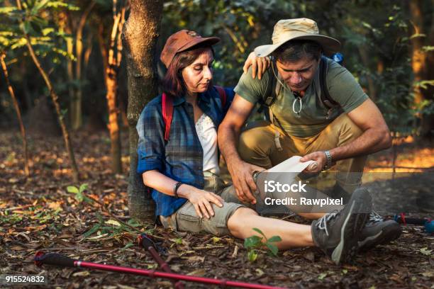 Man Putting Bandage On His Partner Knee In The Jungle Stock Photo - Download Image Now