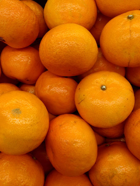 istock Fresh mandarin oranges on a market, texture background 915527408
